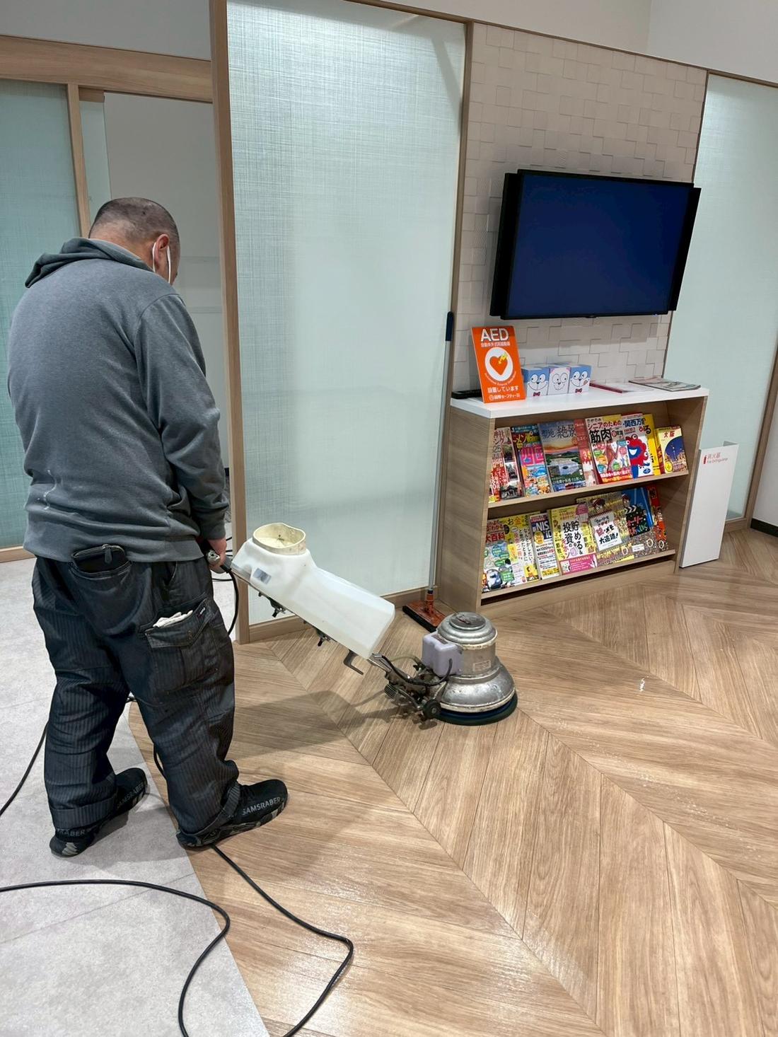 ポリッシャーで床面を洗浄するスタッフ