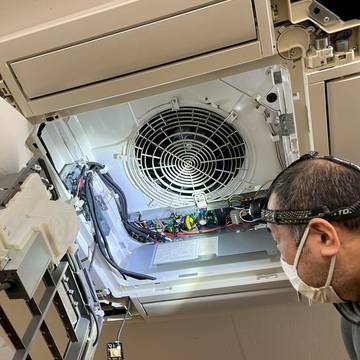 天井カセットエアコンを分解するスタッフ