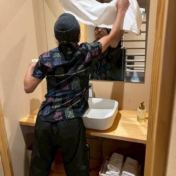 タオルを広げて洗面を仕上げるスタッフ